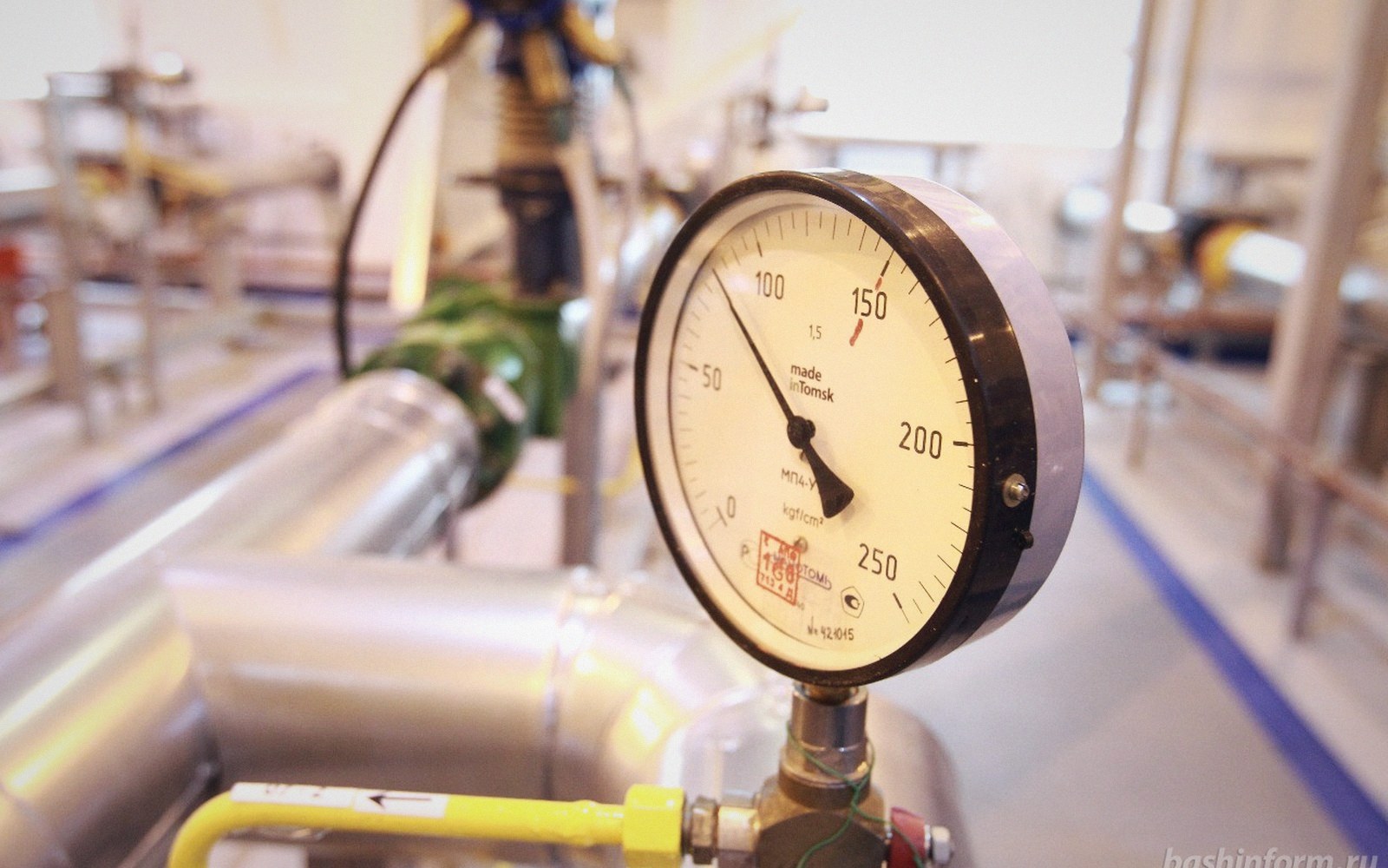 Pressure gauge mounted on industrial pipework in a gas processing facility