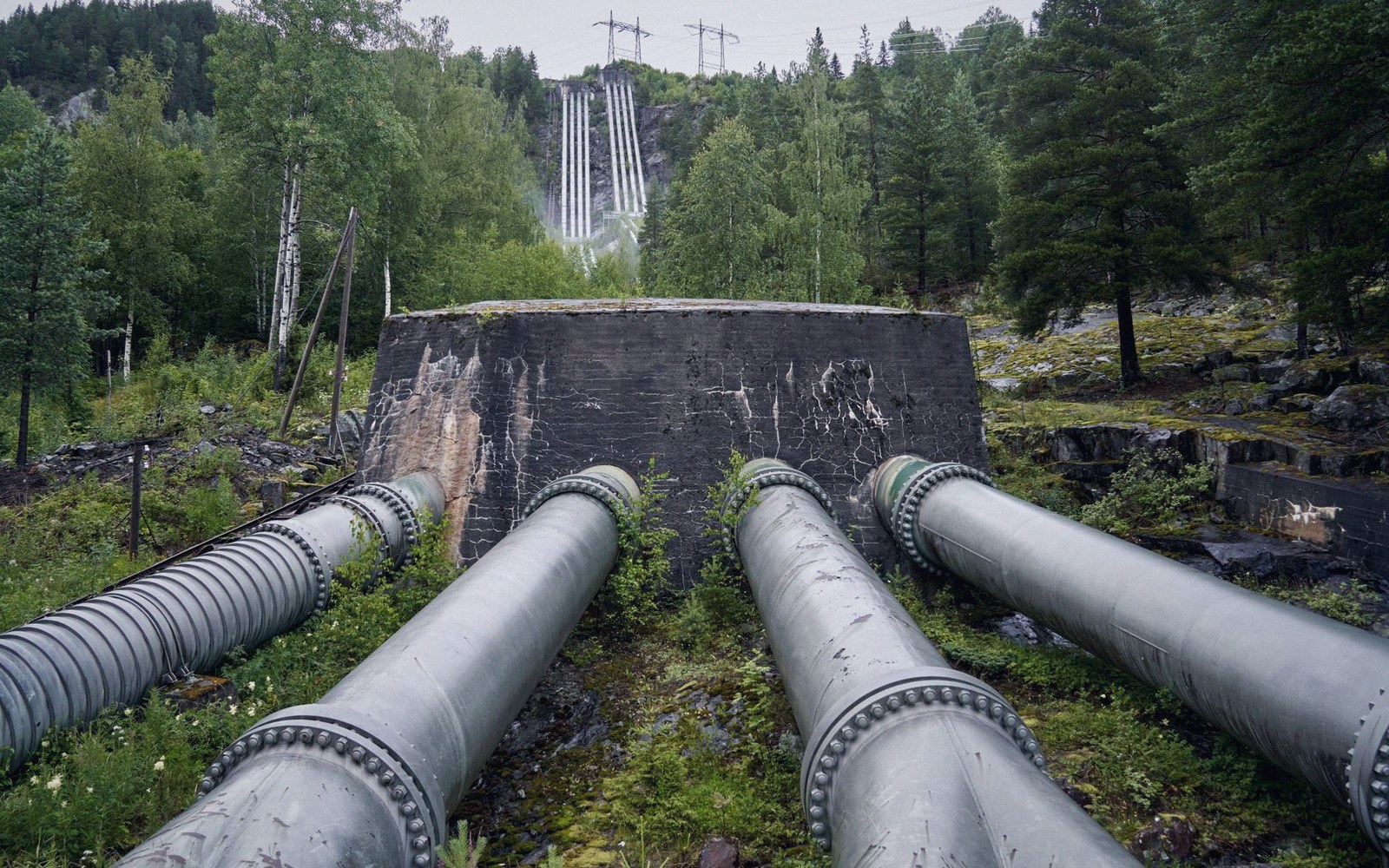 Steel penstocks running down a mountainside to a hydro station