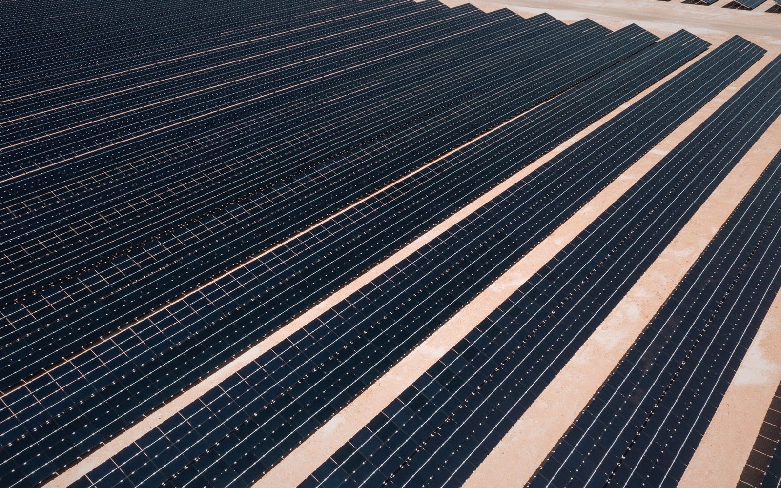 A utility-scale solar field on flat southern ground, rows receding